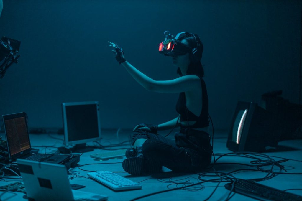 Kokcha International Woman immersed in virtual reality, surrounded by tech, in a dimly lit room. Kokcha International Woman immersed in virtual reality, surrounded by tech, in a dimly lit room.
