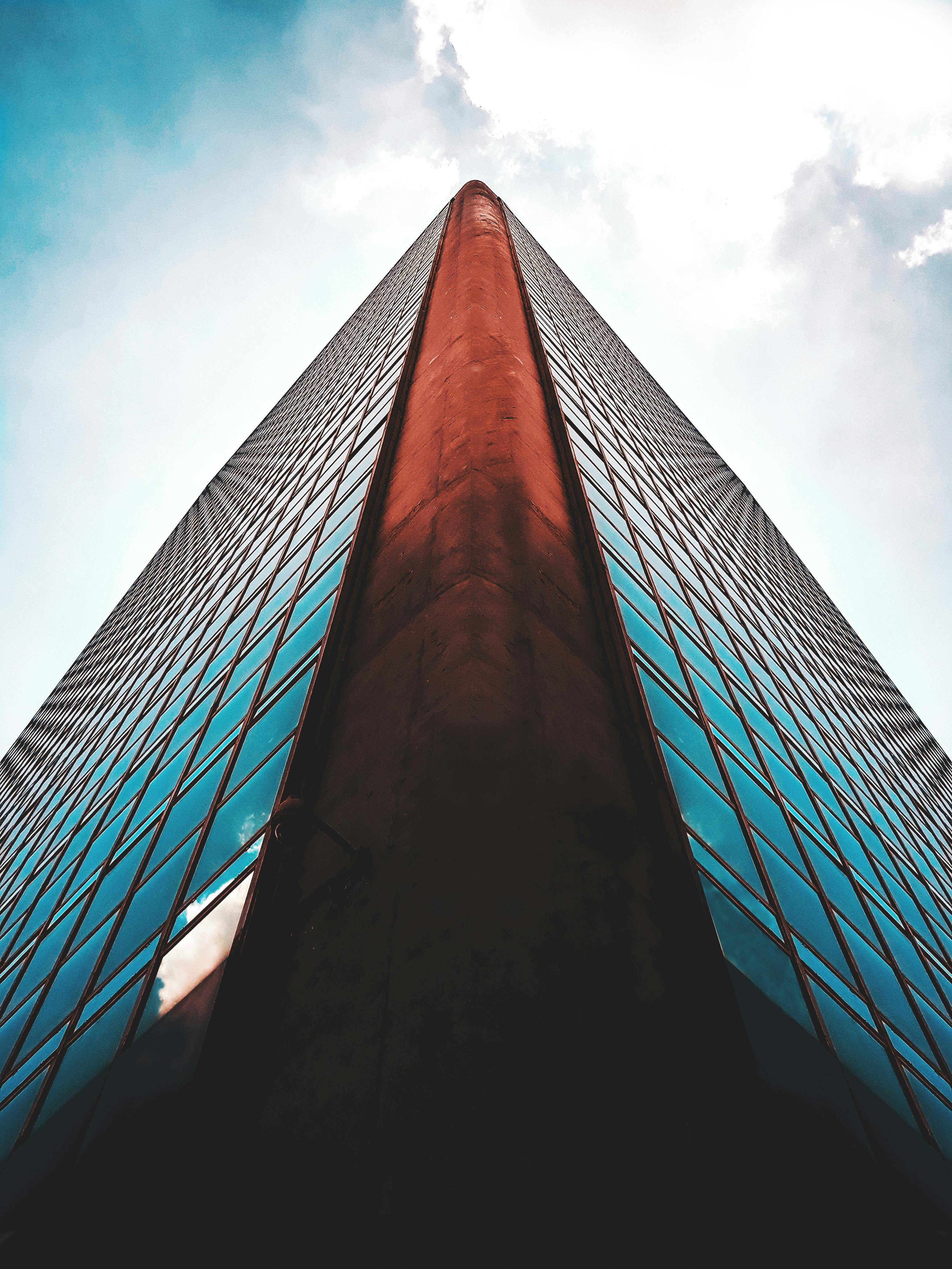 pexels-photo-2071216-2071216 Striking low angle view of a modern skyscraper with reflective glass windows against a blue sky.